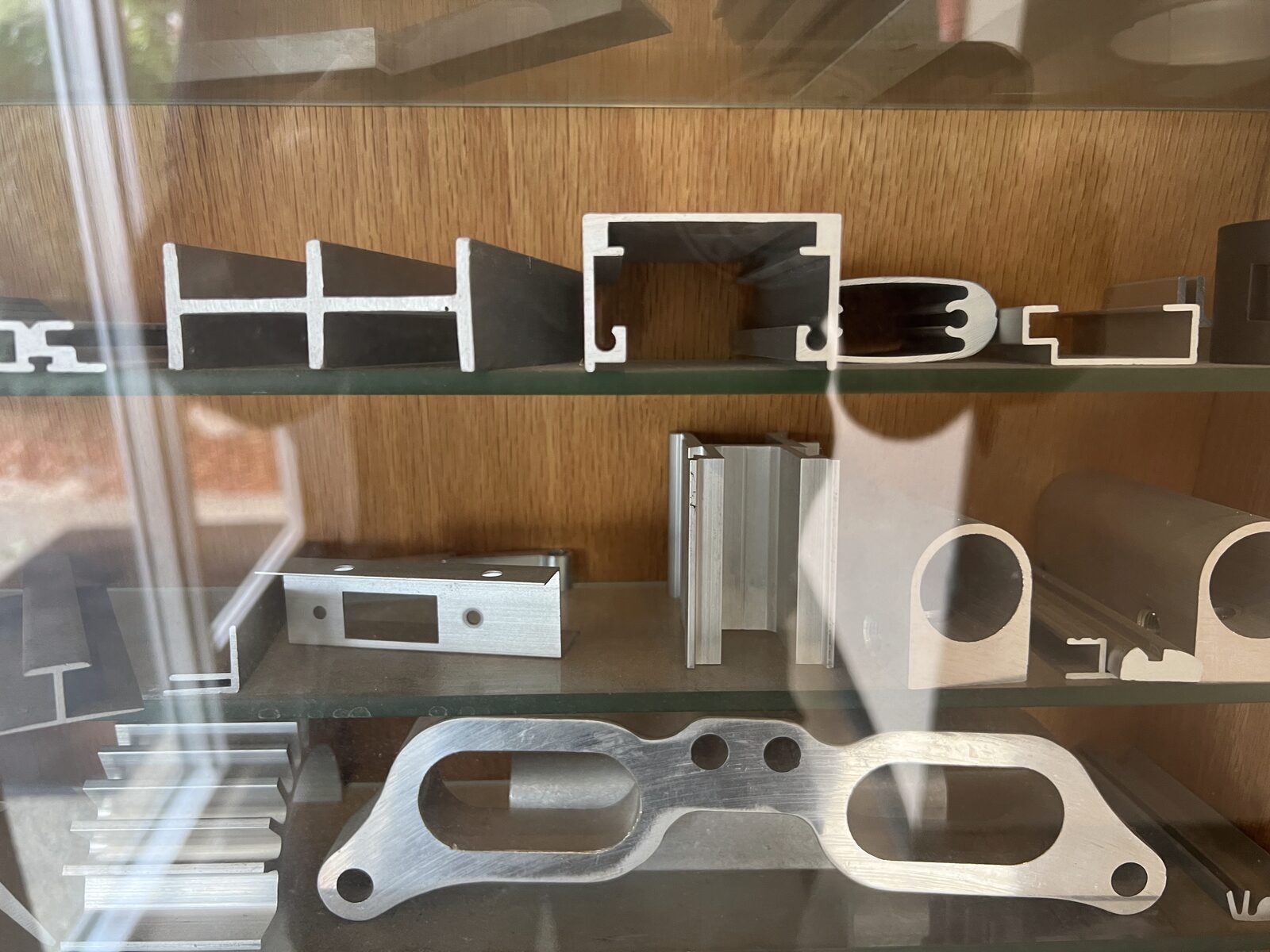 Two extruded aluminum profiles side by side — a finer architectural profile and a heavier structural profile